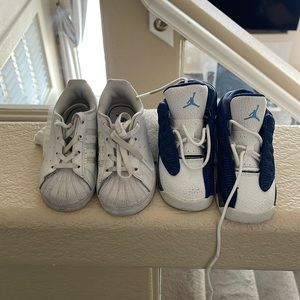 Two pair of sneakers, Jordans, blue and white, and one pair of Adidas white